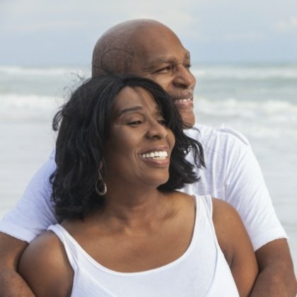 Older couple smiling and enjoying the benefits of dental implants