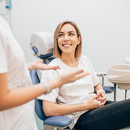 dentist talking to patient in treatment chair 