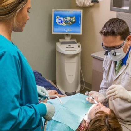 Dentist and team member treating dental patient using one visit dentistry technology