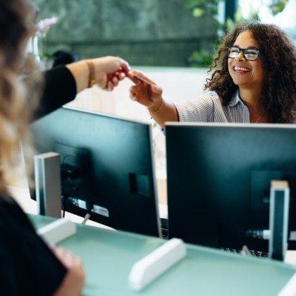 Dental patient handing team member a credit card