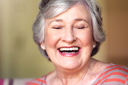 Senior woman smiling wit eyes closed