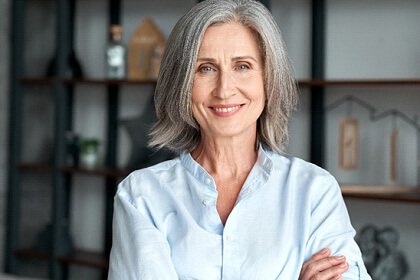 senior woman smiling with arms folded