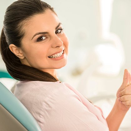 Female dental patient giving a thumbs up