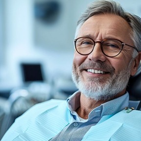 a patient smiling after receiving his dentures
