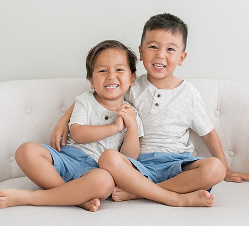 Two Children hugging on couch