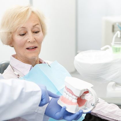 A dentist explaining the implant denture process to a patient
