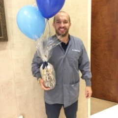 Dentist holding gift and balloons in dental office in the Lake Nona Region