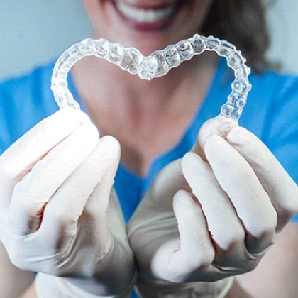 dentist forming heart with Invisalign aligners