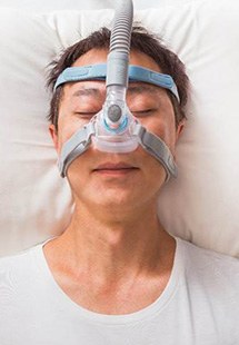Woman with sleep apnea therapy device sleeping