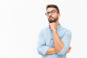 Man with glasses and blue shirt looking thoughtful